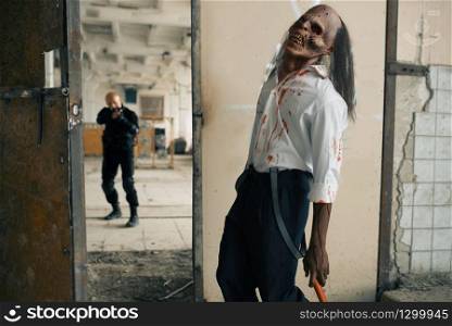 Man with gun fights with undead zombie, nightmare in abandoned factory. Horror in city, creepy crawlies, doomsday apocalypse, bloody evil monster