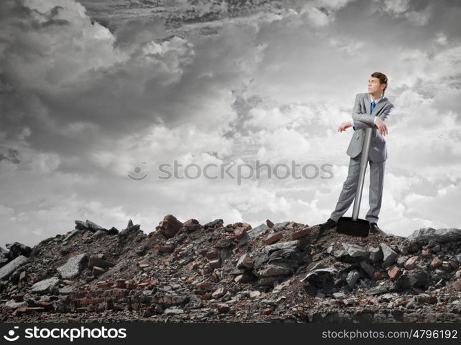 Man with hammer. Young businessman with hammer standing on ruins