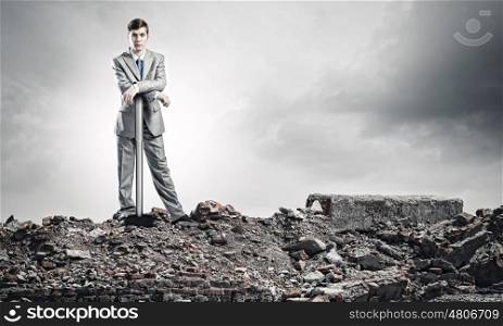 Man with hammer. Young businessman with hammer standing on ruins