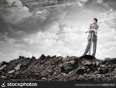 Man with hammer. Young businessman with hammer standing on ruins