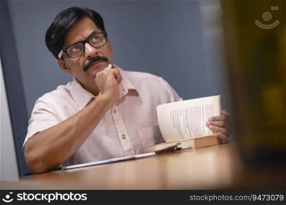 Man with hand on chin thinking deeply while taking notes