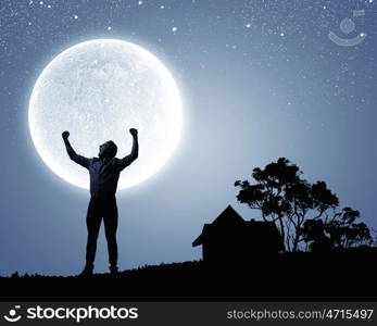 Man with hands up. Silhouette of screaming man celebrating success