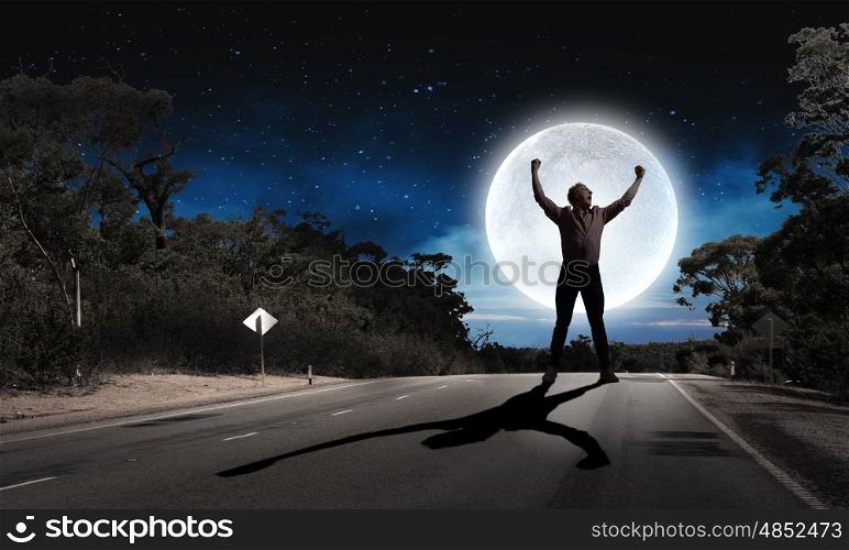 Man with hands up. Silhouette of screaming man celebrating success