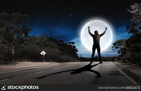Man with hands up. Silhouette of screaming man celebrating success