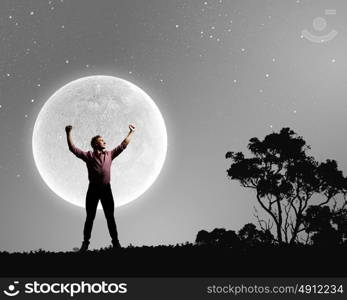 Man with hands up. Silhouette of screaming man celebrating success