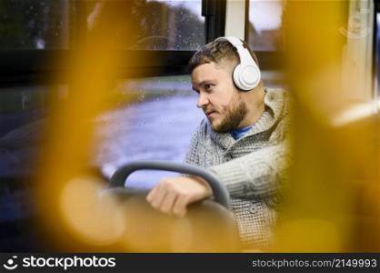 man with headphones traveling by bus