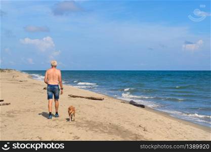 Man with his dog at the Corsican beach