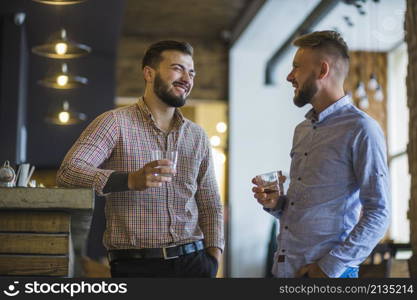 man with his friend holding glass whiskey bar