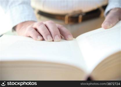 man with his hands on a large book