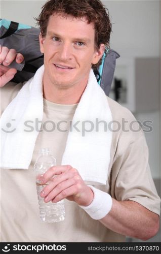 Man with his kitbag and water after exercising