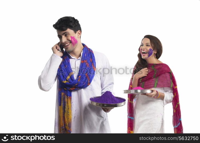 Man with holi colour talking on a mobile phone