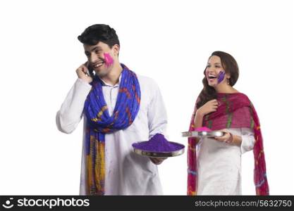 Man with holi colour talking on a mobile phone