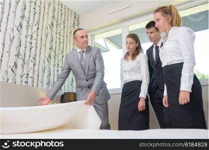 Man with hotel staff, holding bedspread