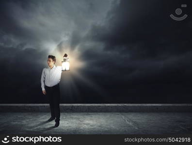 Man with lantern. Young handsome businessman walking with lantern in darkness