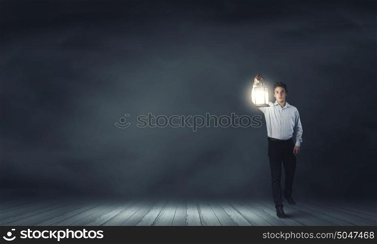 Man with lantern. Young handsome businessman walking with lantern in darkness