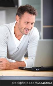 Man with laptop computer in kitchen