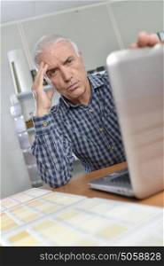 Man with laptop, looking troubled