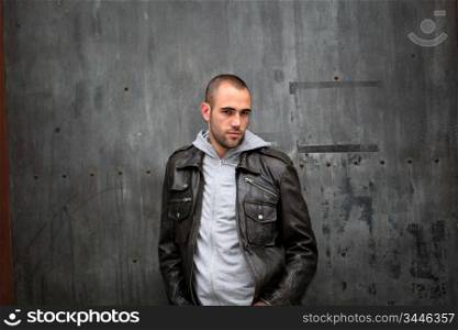 Man with leather jacket standing on metal door