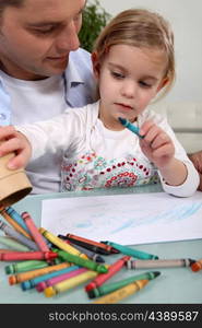 Man with little girl colouring