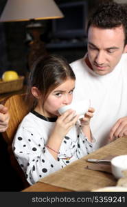 Man with little girl having breakfast