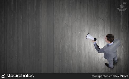 Man with megaphone. Top view of businessman screaming in megaphone