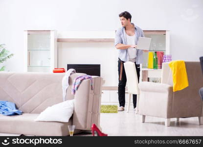 Man with mess at home after house party