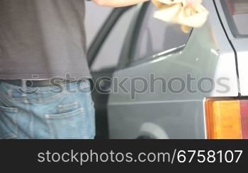 man with microfiber wiping car after washing