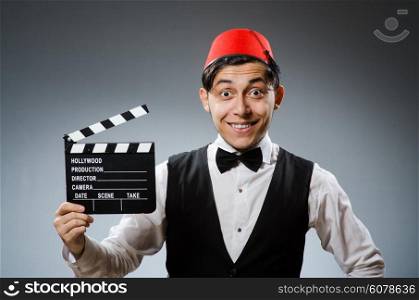 Man with movie board wearing fez hat