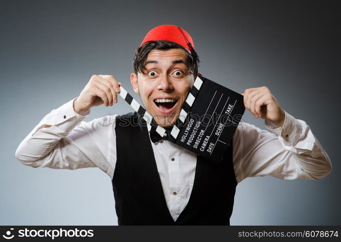 Man with movie board wearing fez hat