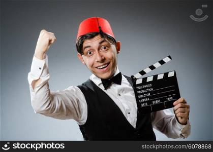 Man with movie board wearing fez hat