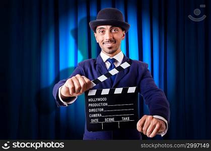 Man with movie clapper on curtain background