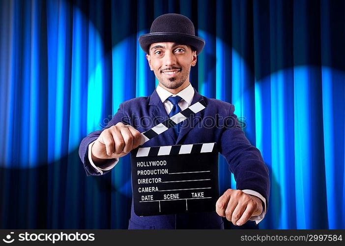 Man with movie clapper on curtain background