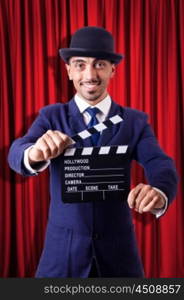 Man with movie clapper on curtain background