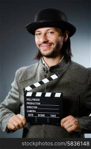 Man with movie clapperboard and hat