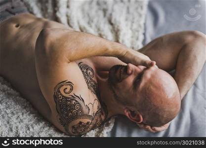 Man with naked torso lying on the bed.. Portrait of the hunky men resting on the bed 22.