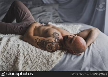 Man with naked torso lying on the bed.. Portrait of the hunky men resting on the bed 20.