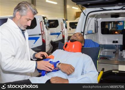 Man with neck brace at open doors of ambulance