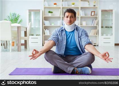 Man with neck injury meditating at home on floor