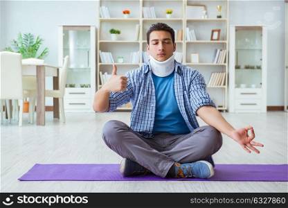 Man with neck injury meditating at home on floor. The man with neck injury meditating at home on floor