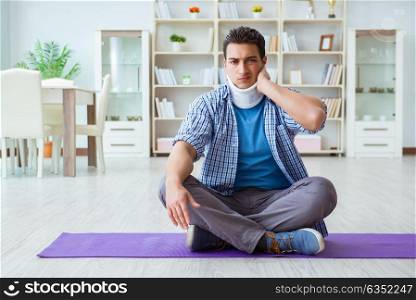 Man with neck injury meditating at home on floor. The man with neck injury meditating at home on floor