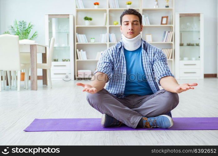 Man with neck injury meditating at home on floor