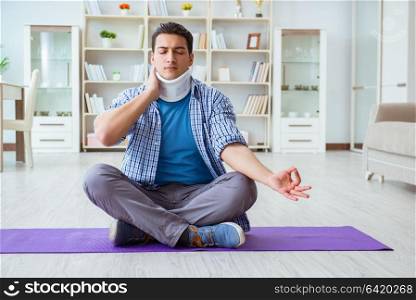 Man with neck injury meditating at home on floor