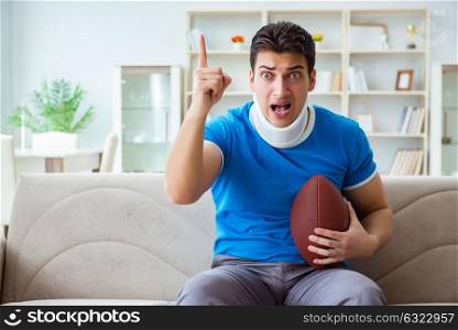 Man with neck injury watching american football at home