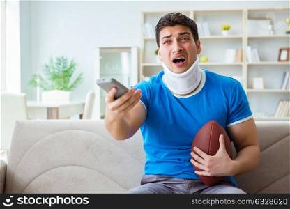 Man with neck injury watching american football at home. The man with neck injury watching american football at home