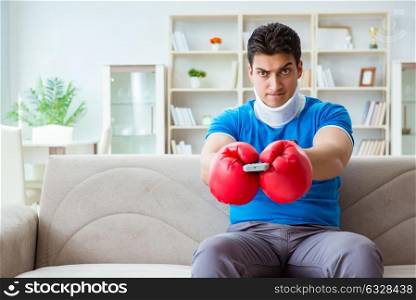 Man with neck injury watching boxing at home. The man with neck injury watching boxing at home