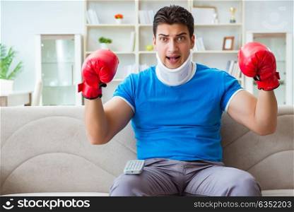 Man with neck injury watching boxing at home