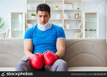 Man with neck injury watching boxing at home