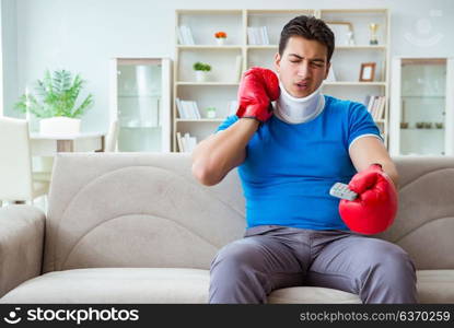 Man with neck injury watching boxing at home