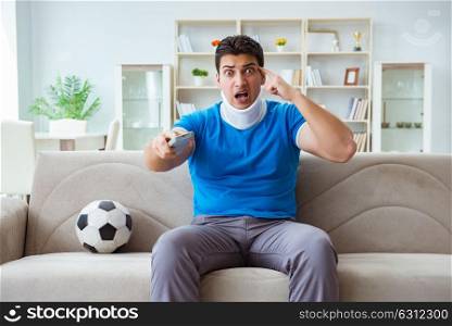 Man with neck injury watching football soccer at home. The man with neck injury watching football soccer at home