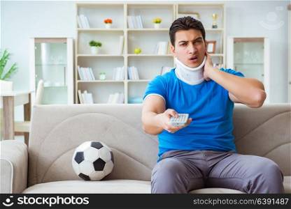 Man with neck injury watching football soccer at home